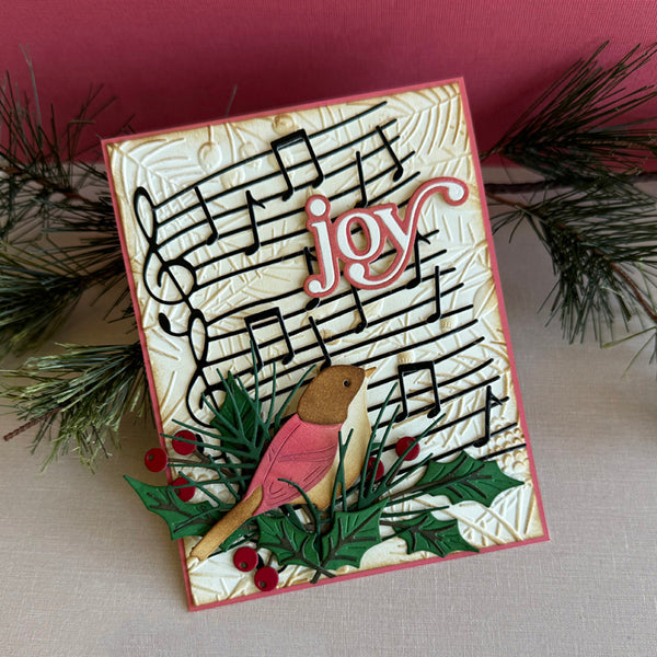 Greeting card with musical notes and 'joy' text, featuring a bear and holly design.