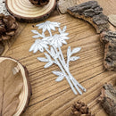 Metallic floral cutout on a wooden surface with natural elements