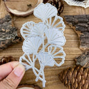 Metallic leaf-shaped cutting die held over a wooden background