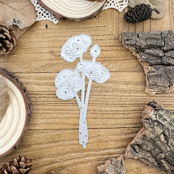 Decorative paper cutout of a floral design on a wooden surface with natural elements.