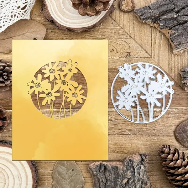 Metallic gold and silver floral cutouts on a wooden surface with natural elements.