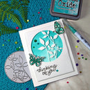 Card with butterfly design and 'thinking of you' text, surrounded by stamping tools on a textured surface.