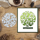 Card with leaf design and 'Happy Birthday' text on a wooden surface with decorative elements.