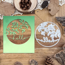 Decorative metal cutting dies with leaf design on a wooden surface with pinecones and leaves.