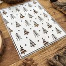Metal stencils with tree patterns on a wooden surface