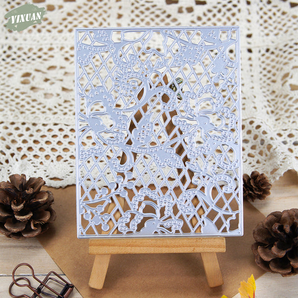 Decorative metal cutting die on a small easel with pinecones and a lace background