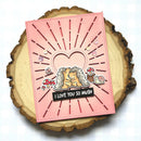 Pink card with heart design and cartoon lions on a wooden surface