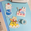 Decorative paper cutouts of a bear, cat, and rabbit with text and graphics on a blue surface.