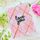 Heart-shaped card with 'love you' text on a pink and gold grid design, surrounded by flowers.