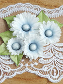 Decorative flowers with pearl centers on a lace doily