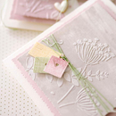 Decorative card with floral design and small embellishments on a light background