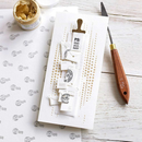 Set of stamps on a white card with a wooden handle tool on a patterned surface