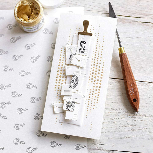 Set of stamps on a white card with a wooden handle tool on a patterned surface