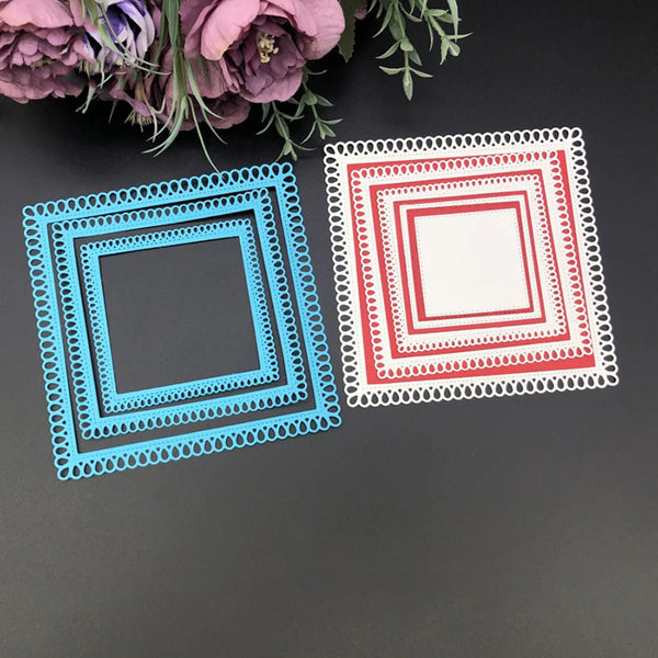 Two square cutout shapes, one blue and one red with white lace trim, on a dark surface with flowers in the background.