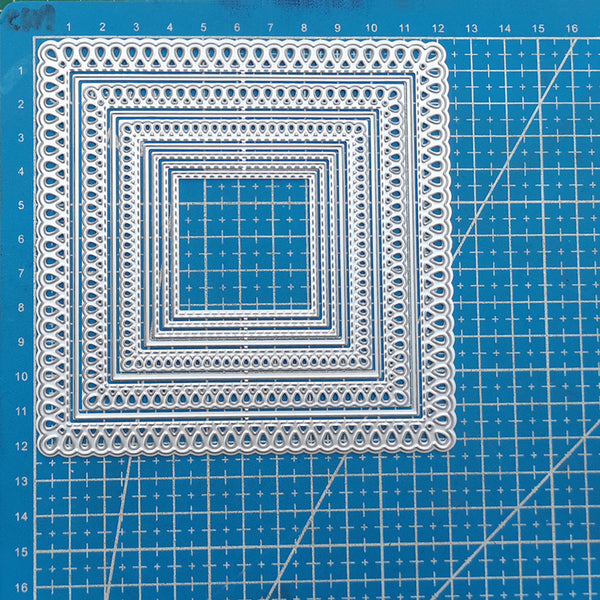 Decorative square cutout on a blue cutting mat with grid lines