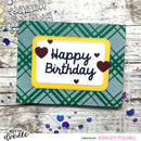 Handmade birthday card with 'Happy Birthday' text and heart decorations on a green plaid background.