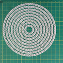 Circular pattern of white strings on a green grid background