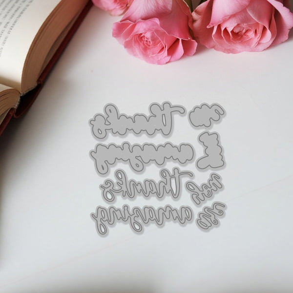 Metal die cut with decorative text on a white surface with pink roses
