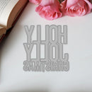Decorative cutout with 'Merry Christmas' text on a white surface with pink roses and an open book.