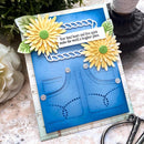 Handmade card with sunflower decorations and a blue background on a textured surface.