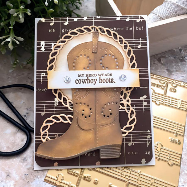 Card with cowboy boot design and text 'My hero wears cowboy boots' on a music sheet background.