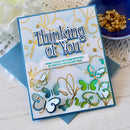 Greeting card with butterfly design and 'Thinking of You' text on a white surface.