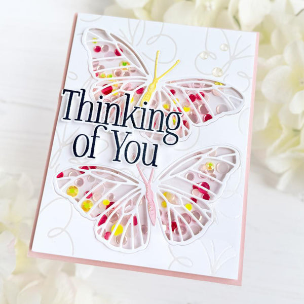 Greeting card with butterflies and 'Thinking of You' text on a soft background