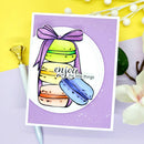 Card with colorful macarons and a purple bow on a yellow background