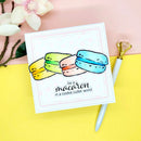 Card with colorful macaron illustration and text on a pink and yellow background