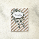 Greeting card with striped design and leaf pattern on a textured surface