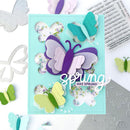 Card with colorful butterfly cutouts and 'spring has sprung' text on a light blue background.