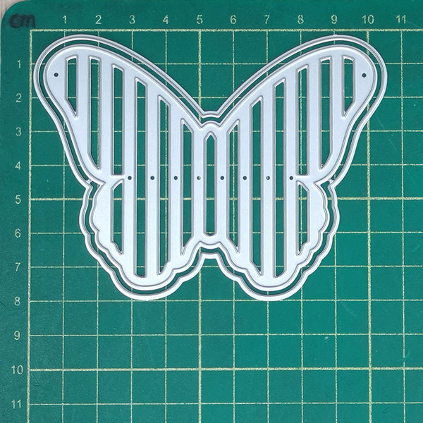 Butterfly-shaped cutting die on a green grid background