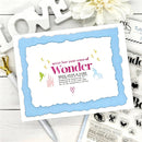 Card with 'never lose your sense of wonder' text on a white surface with decorative items.