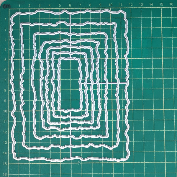 Set of white cutting dies on a green grid background