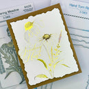 Card with floral design and 'Sending Hugs' text, surrounded by stamping tools.