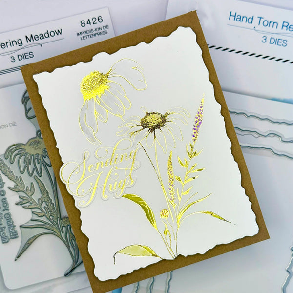 Card with floral design and 'Sending Hugs' text, surrounded by stamping tools.
