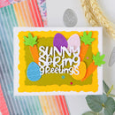 Colorful card with 'Sunny Spring Greetings' text and Easter-themed decorations on a textured surface.