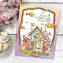 Underwater-themed card with fish and a house, placed on a wooden surface with flowers and shells.