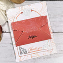 Decorative card with a red envelope and 'Thank you' text on a wooden surface