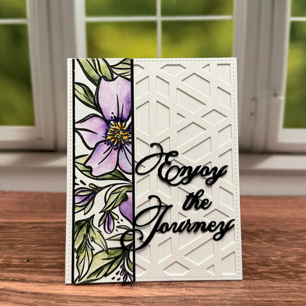 Greeting card with floral design and 'Enjoy the Journey' text on a wooden surface.