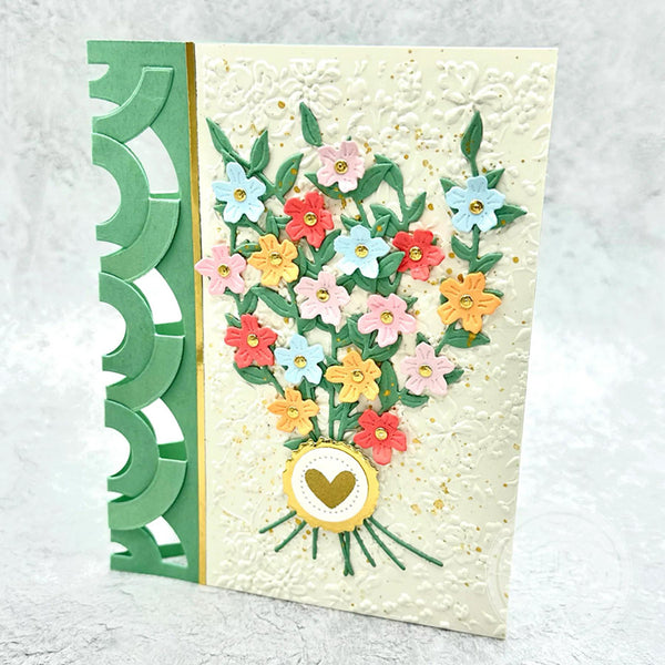 Greeting card with colorful floral design and green border on a textured surface