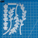 Metal die cutters with floral and leaf designs on a blue cutting mat.