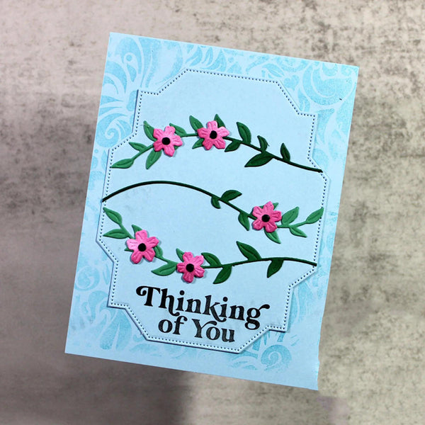 Greeting card with floral design and 'Thinking of You' text on a textured surface