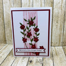Card with red floral design and text on a wooden background