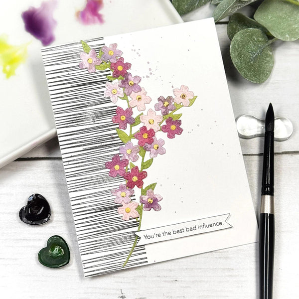 Card with floral design and barcode, placed on a wooden surface with decorative elements.