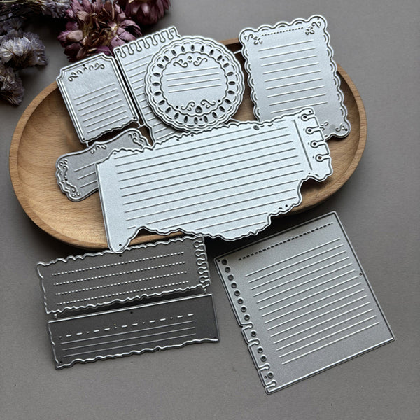 Set of metal dies with various shapes on a wooden board against a gray background
