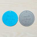 Two round embossing stamps with 'Happy Birthday' text and butterfly design on a textured surface.