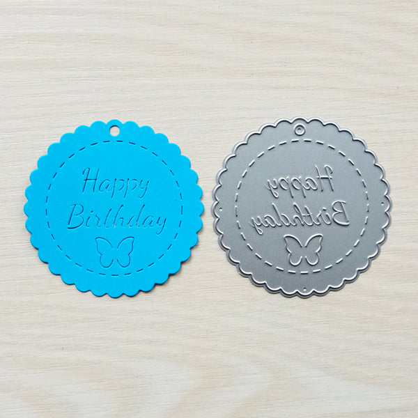 Two round embossing stamps with 'Happy Birthday' text and butterfly design on a textured surface.