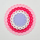 Stack of colorful lace doilies on a light gray background