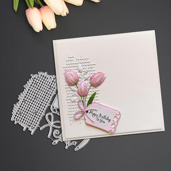 Card with pink tulips and 'Happy Birthday' tag, accompanied by a metal cutting die on a dark background.